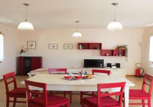 PolcenigoAlbergo Diffuso Polcenigo C.Barnard的客厅配有桌子和红色椅子
