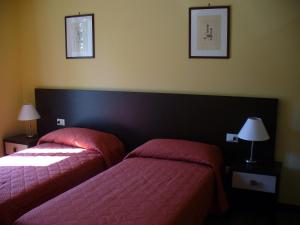 Tortoreto AltoAppartamento IL POGGIO的两张位于酒店客房的床铺,配有粉红色床单