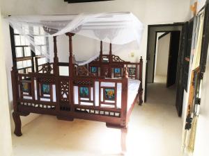ShelaFuraha House的一张木床,在房间内有天蓬