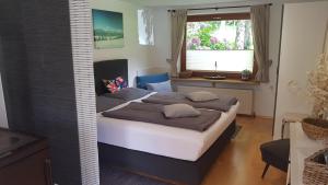 滨湖采尔甘德尔公寓的一间卧室设有一张床和一个窗口