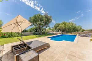 马翁Villa Mala Bay的一个带椅子和遮阳伞的庭院和一个游泳池