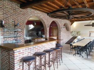 奥德纳尔德Hof Ten Beemd的厨房设有砖墙和带凳子的酒吧