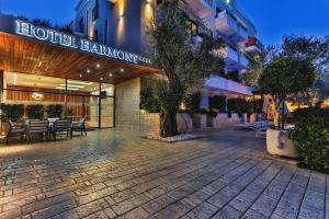 佩特罗瓦纳莫鲁Hotel Harmony by Aycon的大楼前带桌椅的酒店走廊