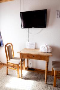 Gasthaus Freihof的一张木桌、椅子和墙上的电视
