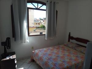 瓜拉派瑞Casa de praia; Itapebussu, Guarapari, ES.的一间卧室设有一张床和一个窗口