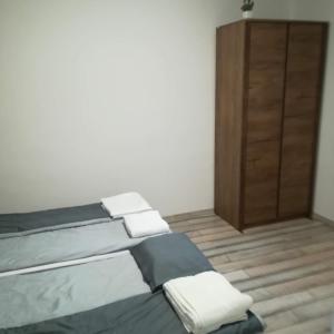 欧罗什哈佐Golden Apartman的一间卧室配有一张床和一个木制橱柜