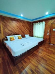 Ban Dong KlangPalmsuay Resort的铺有木地板的客房内的一张大床