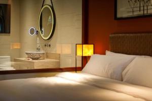 攀瓦海滩Phuket Panwa Beachfront Resort的卧室配有水槽、床和镜子