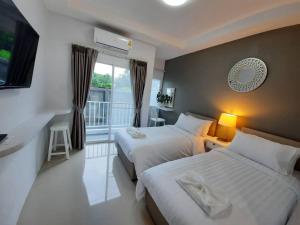 清莱The Viera Chiangrai的酒店客房设有两张床和一个阳台。