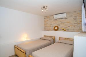 奥尔比亚Appartamento del Cormorano的墙上的房间里设有两张床