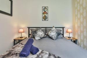 谢菲尔德Refurbished Plush Property Great Transport Links的一间卧室配有一张带紫色毯子和两盏灯的床。
