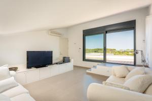 埃斯卡纳特尔Villa Canutells Ref 27的客厅配有白色家具和平面电视