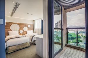 台北洛碁大饭店松山馆的酒店客房设有两张床和大窗户。