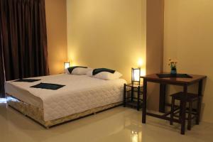 沙湾拿吉阿瓦隆公寓的一间卧室配有一张床和一张桌子及一张桌子