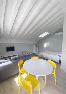 桑提亚纳德玛La Fragua的配有白色桌子、椅子和床的房间