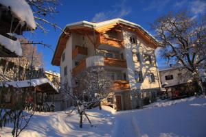 费德拉帕加内拉Cortalta Mountain Lodge的前面的地面上积雪的房子