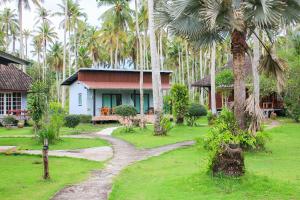 库德岛Koh Kood Far East Resort的一座房子,有一条通往棕榈树的小路