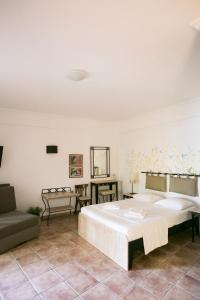 佩科霍里阿蒙花园酒店的卧室配有一张白色的大床和一张沙发。