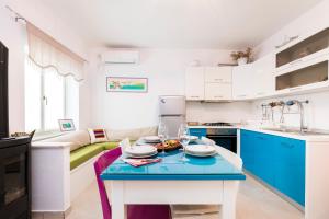 木洛希尼Casa Maria 2的厨房配有蓝白色橱柜和桌子
