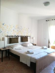 佩科霍里阿蒙花园酒店的一间卧室配有一张带白色床单的大床