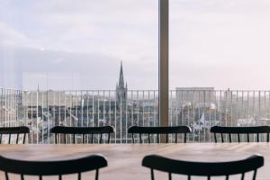 鲁汶De Hoorn的一张桌子和椅子,享有城市美景
