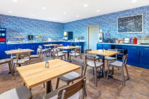 艾恩芒廷艾伦山乡村套房酒店的餐厅拥有蓝色的墙壁和木制桌椅
