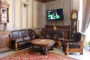 大特尔诺沃Park Hotel Ivailo的客厅配有皮革家具和时钟