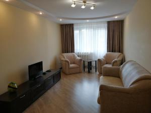 罗夫诺Big Apartment in Rivne center的客厅配有沙发、两把椅子和电视