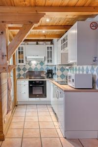 梅塔比耶Appartement privatif type chalet cosy et calme的一间厨房,配有白色家电和木制天花板