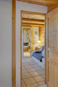 梅塔比耶Appartement privatif type chalet cosy et calme的一间卧室配有一张床,一扇门通往房间