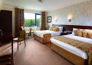 基尔特马Kiltimagh Park Hotel的酒店客房配有两张床和一张书桌