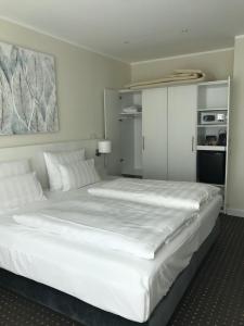 奥茨塞巴德·迪尔哈根费斯和兰德斯特瑞德酒店的卧室配有白色大床和白色枕头