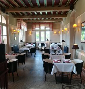 布里阿尔Le Domaine des Roches, Hotel & Spa的用餐室设有桌椅和窗户。