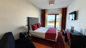 纳扎雷苏尔美丽华酒店的一间卧室配有一张带红色枕头的床和一扇窗户
