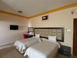 Ḩilf达纳阿尔卡勒酒店的一间酒店客房,设有两张床和电视