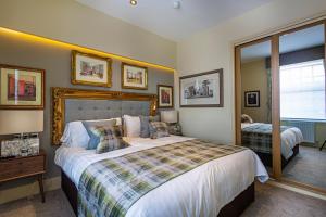 贝克韦尔The Rutland Arms Hotel, Bakewell, Derbyshire的一间卧室配有一张大床和镜子