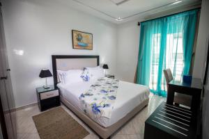 丹吉尔Appart Hotel Rania的一间卧室配有一张带蓝色窗帘的大床