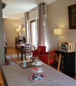 鲁汶德帕斯托里酒店的客厅配有桌子和红色沙发