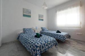 阿尔姆尼卡Villa gaviota的一间卧室设有两张床和窗户。