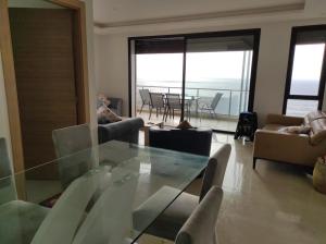 塞拉Bel appartement à plage des Nation的客厅配有玻璃桌和椅子