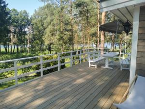 WąglikowiceSosnowy Azyl的木制甲板上配有长凳和遮阳伞