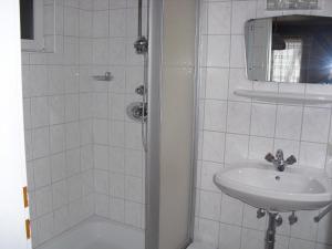 Haibach ob der Donau祖姆赫利根尼古劳斯宾馆的白色的浴室设有水槽和淋浴。