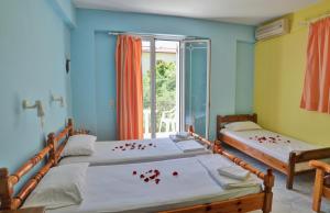 瓦西里科斯扎金索斯丽城一室公寓的宿舍间内的两张床,上面有红花瓣