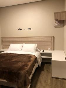 格拉玛多Apartamento Luxo em Gramado的卧室配有一张大床,墙上有三只鸟