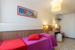 威尼斯伊尔摩洛威尼斯酒店的一间卧室配有一张带红色枕头的紫色床