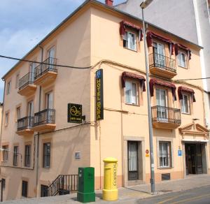 普拉森西亚Hotel Dora的街道拐角处的黄色建筑