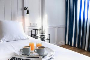 帕拉莫斯玛瑞娜酒店的一张带两杯咖啡和两杯橙汁的床