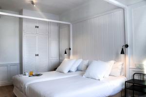 帕拉莫斯Hotel & Restaurant Marina Palamós的白色卧室配有一张带白色枕头的大床