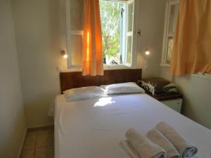 费拉圣托里尼岛露营/客房酒店的卧室配有白色的床和2条毛巾