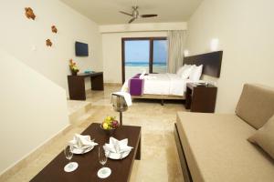 艾库玛尔Akumal Bay Beach & Wellness Resort的客厅配有床和沙发